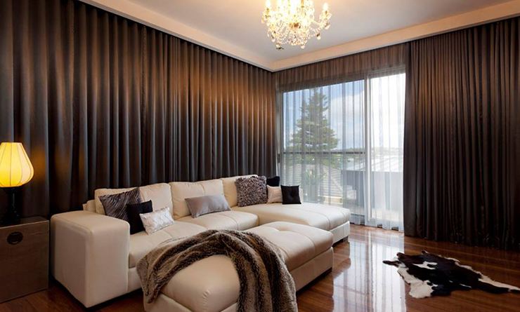 Chocolate blockout curtains lining the walls of a lounge room