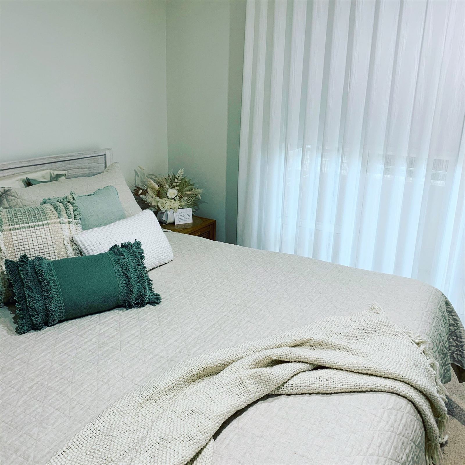 Floor-length white sheers in a light, calm bedroom